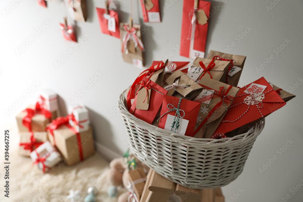 Wall mural Making Christmas advent calendar. Basket full of paper bags with gifts