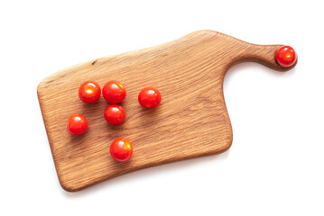 Creative flat lay layout of fresh vegetables tomatoes on a wooden board on a white background.