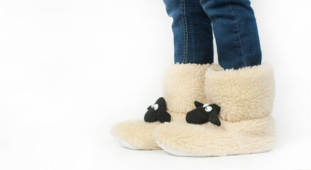 Part of the legs of warm Christmas uggs in the shape of a lamb. Slippers stockings on a white background.
