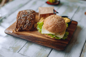 Appetizing fast food lunch on a wooden stand with french fries and sauce. Close up.