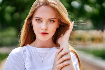 The teenage girl on the street straightens her hair. close up