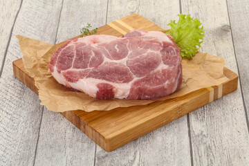 Raw pork steak over wooden board