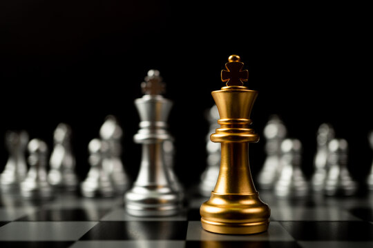 Golden King chess standing in front of other chess, Concept of a leader must have courage and challenge in the competition, leadership and business vision for a win in business games