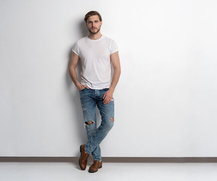 Full length studio portrait of casual young man in jeans and shirt. Isolated on white background.