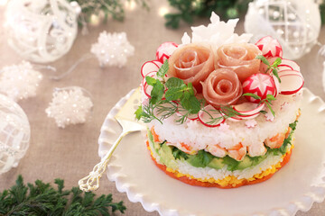 Obraz na płótnie Canvas Christmas layered salad with salmon, avocado, shrimp, and vinegared rice on holiday decoration table.　ケーキ寿司　クリスマス