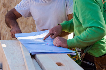 Obraz premium foreman examining construction of a wooden house