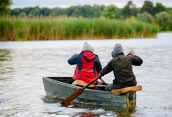 two fishermen in a boat going fishing