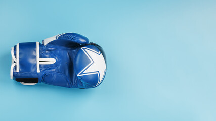 Blue Boxing glove on a blue background, free space.