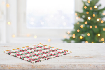 Checkered napkin on table and frosty window with christmas tree