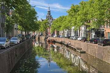 Gouda, Netherlands. View on the tower of Sint Janskerk (St John the Baptist Church) from the Nood-Godsbrug bridge across the Gouwe river in sunny day.