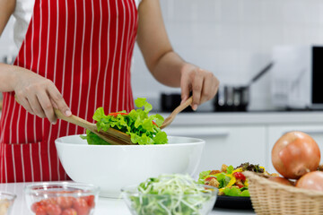 Obraz na płótnie Canvas Chef mixing salad in white bowl.