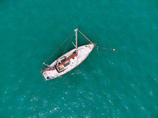 Amazing sail boat is sailing across the deep blue sea. Top view.