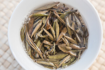 Bai Hao Yin Zhen (White Hair Silver Needle) white tea leaves steeping in a gaiwan/Zhong, Gong Fu Cha brewing. Beautiful full bud leaves perfectly processed. Top view.