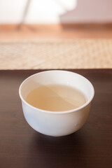 Beautiful porcelain tea cup close up shot. Hydrating pale liquor in it.
Bai Hao Yin Zhen (White Hair Silver Needle) white tea from Fujian province. Vertical shot.