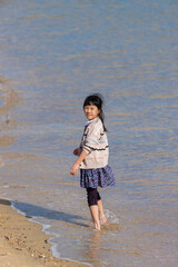 綺麗な海の砂浜で砂遊びしている可愛い子供