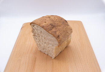 A plain white loaf cut in half on a bread board isolated against a white background
