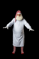 Santa Claus in pajamas walks through the darkness trying to grope for something in the dark on a...