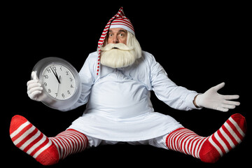 Santa Claus in a nightgown and a nightcap sits on the floor and does not understand why he is late...