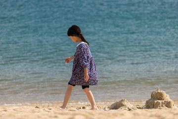 綺麗な海の砂浜で砂遊びしている可愛い子供