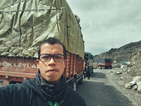Portrait Of Man Wearing Eyeglasses While Standing Against Truck