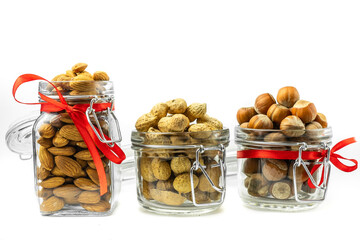 Three glass jars of nuts. Isolated on a white background