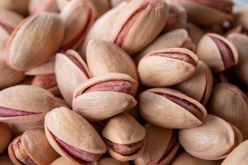 pistachios in bowl - on wooden background - close up