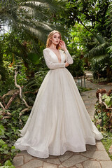 Fototapeta premium Beautiful woman bride fashion model blond hair bright makeup pretty wear long silk white dress with lace bridal ceremony wedding espousal in blooming romance garden party marriage happy big day.