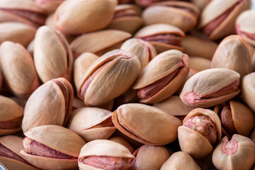 pistachios in bowl - on wooden background - close up