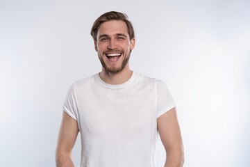 Sexy smiling handsome man in white t-shirt isolated on white.