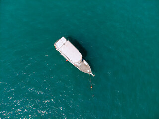 Huge white yacht is sailing alone across the deep blue sea, top view