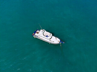 Fototapeta premium Huge white yacht is sailing alone across the deep blue sea, top view