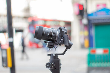 Camera on tripod recording blurry traffic and people on the street