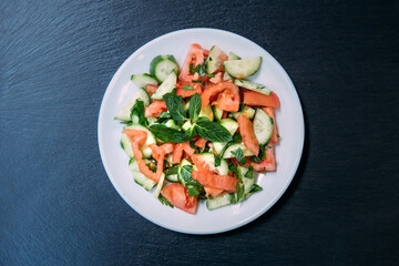 Traditional Turkish salad in the plate on black background