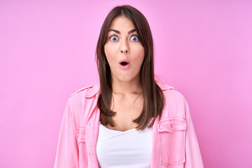 Fototapeta premium Caucasian shocked brunette girl with open mouth, dressed in casual, heard amazing news, happy to receive incredible surprise present isolated in pink studio