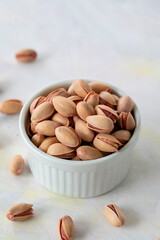 pistachios in bowl - on wooden background