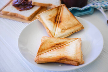 Roasted toast bread popping up of stainless steel toaster in home kitchen