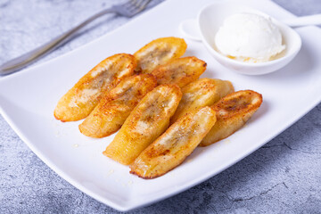 Fried bananas with honey, cinnamon and ice cream. Close-up.