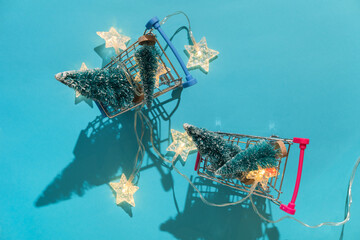 Christmas minimal festive background with star garland in supermarket basket, toy trees. Abstract Christmas and New Year color background blue ai aqua. Bright sparkling wallpaper. Flat lay. Top view.