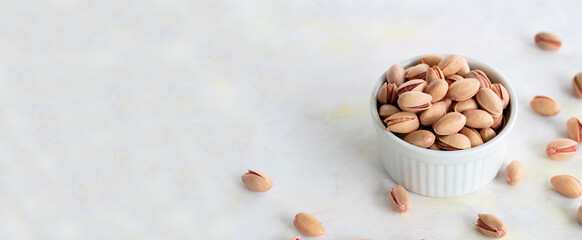 pistachios in bowl - on wooden background- copy space