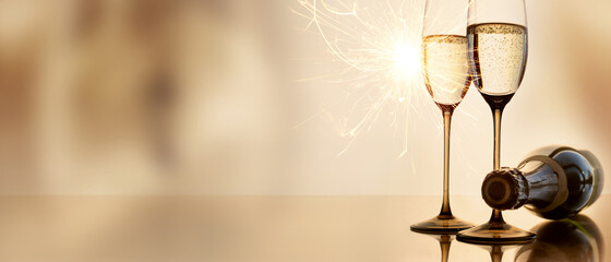 Champagne for new year greetings. Abstract golden background with champagne glasses and sparkler....