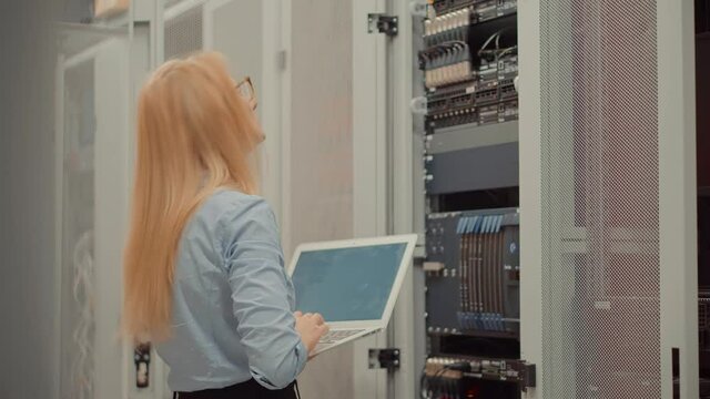 Woman It Engineer Working In Server Room.Network Engineer Work In Data Center.IT Technician Work With Rack Server Cabinet.Digital Secure Specialist In Data Center.It Administrator On Network Hardware