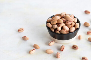 pistachios in bowl - on wooden background