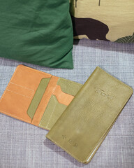 Green handmade leather travel purse for holding passport, money, boarding pass or identification card. Stylish accessory for travelling, documents holder. Vacation and tourism concept.