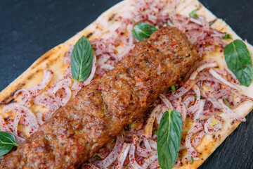 Traditional Turkish grilled shish kebab or kebap. Delicious Adana kebab on black background.
