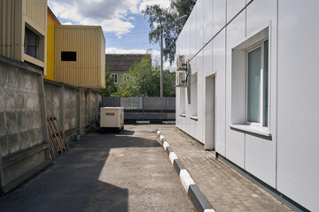The backyard of a gas station with an autonomous standby diesel generator.