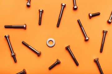 Bolts and nuts closeup on orange background.