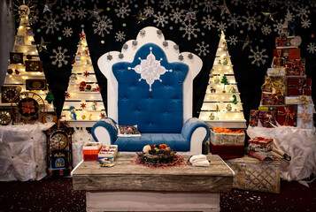 The chair of Santa Claus. Room in the residence is decorated with Christmas trees and garlands.