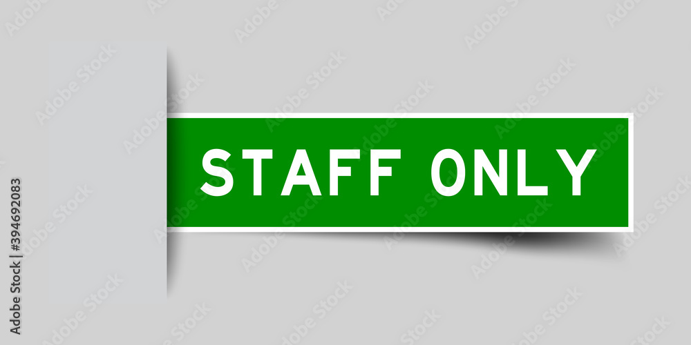 Wall mural Inserted green color sticker label with word staff only on gray background