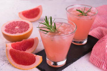 Two glasses with grapefruit juice and ice.
Close-up.