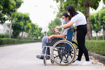 Close-up support or caregivers helping disabled elderly patients sitting on a wheelchair Young...